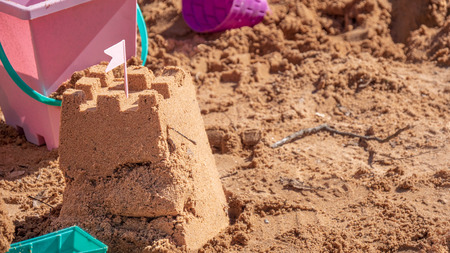 Sand castle surrounded by beach toys