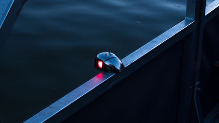 Front bow bi-color boat light showing the red port side, as required by regulations.の写真素材