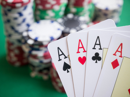 Four aces with poker chips on green tableの写真素材