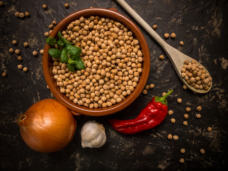 Uncooked chickpeas over stone table. Traditional spanish food ingredient, typical of Madrid. Top viewの写真素材