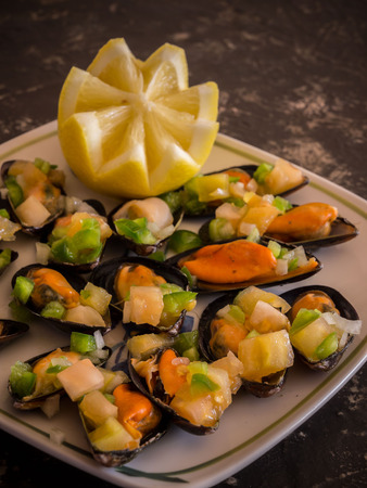 Vinaigrette mussels served on a plate with lemonの写真素材