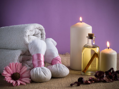 massage products, candles, bottle of oil, flowers and white towelsの写真素材