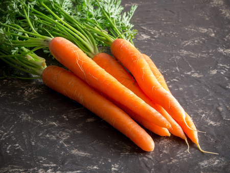 fresh carrots bunch on rustic stone background.の写真素材