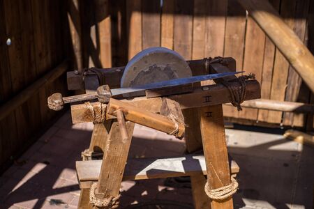 Ancient roman grindstone sharpening swords. historical recreation.