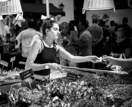 Vilareal de Santo Antonio , Portugal - OCT 12 2.019 - dried fruit seller in street market in black...
