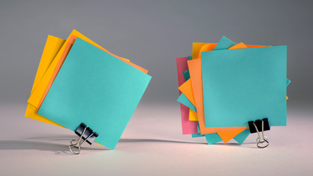 Groups of standing paper notes fastened with paper clips on gray background の写真素材