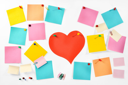 Multiple blank colorful paper notes, office supplies and red paper heart isolated on white background の写真素材