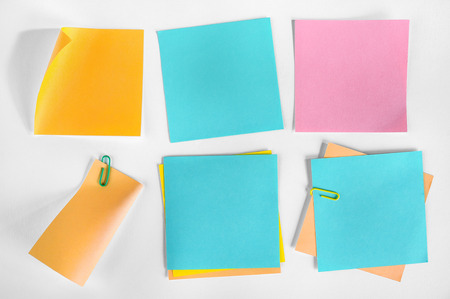 A collection of blank notes of different colors and shapes on white background  の写真素材