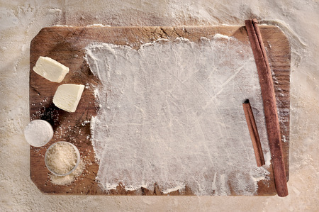 Customizable cooking recipe setup, homemade baking dough, flour, butter, sugar and cinnamon sticks over a  vintage wooden support, top view の写真素材