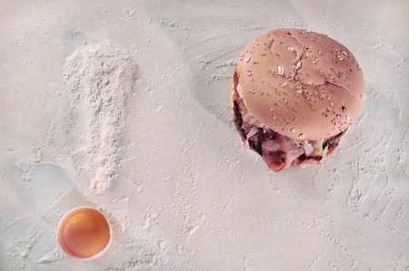 Weight loss concept, exclamation mark made out of natural ingredients  flour and an egg  next to a hamburger の写真素材