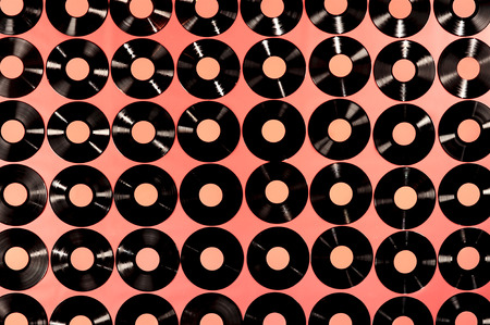 Music - Vinyl records  Collection of vinyl records, LPs, on red background, top view  The labels can be easily customized, the image is suitable for background use  の写真素材