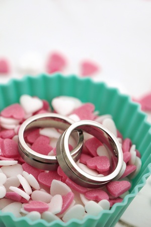 Wedding rings with cute sugar hearts in pink and whiteの写真素材