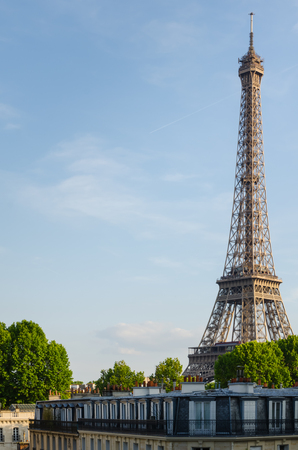 The Eiffel Tower over the roofs of Paris on a sunny dayの写真素材