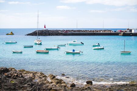 Boats moored at the port of rocky shores of Lanzarote - Seaside landscape