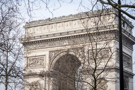 The Arc de Triomphe in Paris through the bare branches of trees in winter - Paris, Franceの写真素材