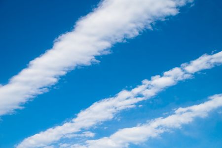 Streaking white clouds on a clear blue sky の写真素材