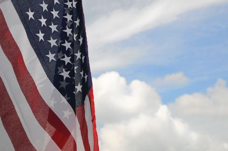 United States flag with partly cloudy sky background