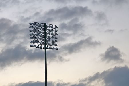 Bank of stadium lights and storm clouds after sunsetの写真素材