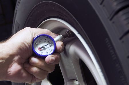 Checking tire pressure to improve gas mileageの写真素材