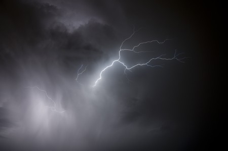 Spectacular display of lightning striking through a rain storm during a Florida summer nightの写真素材