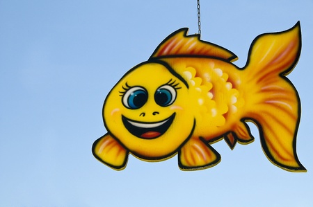 Yellow chain hanging fish mobile with blue sky background