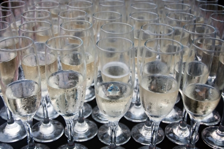 Many glasses filled with champagne ready for a wedding toast with a shallow depth of fieldの写真素材
