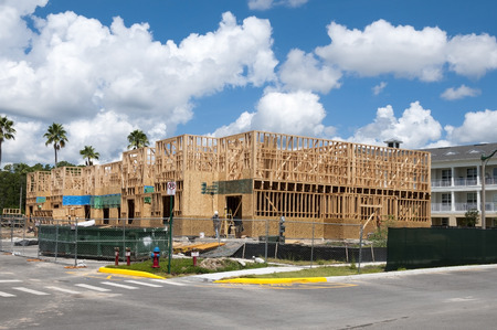 Multi level wood frame building construction with partly cloudy blue sky backgroundのeditorial素材
