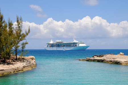Cruise Ship anchored off shore at a lagoon entrance with blue water and skyの写真素材