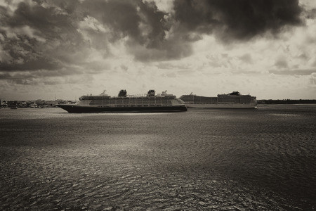 Two Cruise ships coming into port on a stormy tinted dayの写真素材