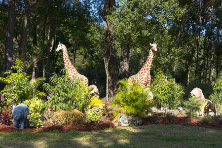 Garden decorated with two Giraffes elephants lions and tigers grazing in the woodsの写真素材