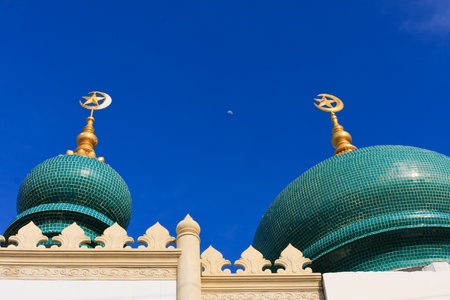 Moon between top of the tiled dome of the ancient mosque in Thailandの写真素材