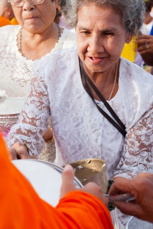 kO SAMUI, THAILAND - AUGUST 3,Unidentified people give food offerings to monks in The Buddhist Lent Day on August 3,2012 Samui island,Thailandのeditorial素材