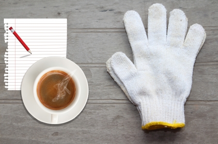 White work gloves,paper and coffee lying on wood floorの写真素材