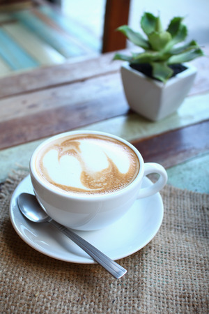 Hearts latte art coffee cup on grunge wood tableの写真素材