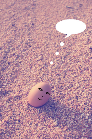 Happy egg sitting on beach with bubble talk in vintage filter effectの写真素材