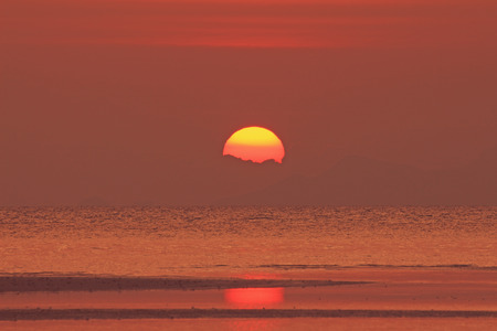 Red sunset over sea with golden light skyの写真素材