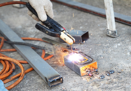Man hand iron welding  at manufacturing 