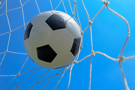 Soccer ball in goal and blue skyの写真素材