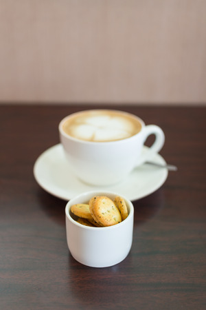 Cup of coffee and biscuits on wooden board の写真素材