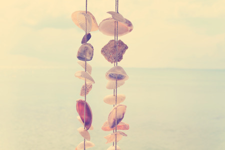 Windbell shell mobile over ocean in vintage styleの写真素材