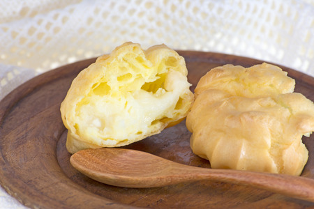 Choux buns or Eclair on wood dish and crochet  white background の写真素材