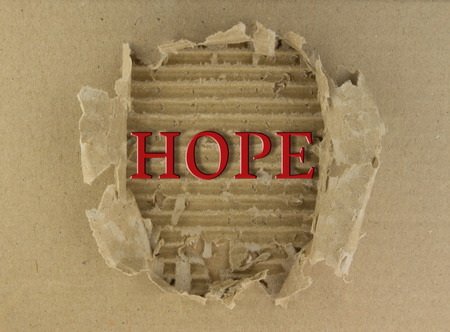 Hope text on torn brown paper backgroundの写真素材
