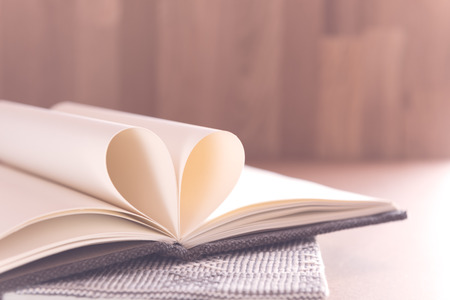 Fold heart paper in heart shape on wooden background,retro filter effect