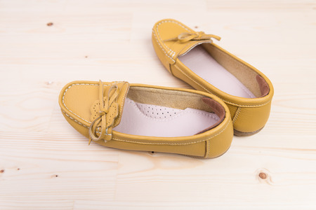 Yellow casual leather flat shoes  on wooden backgroundの写真素材