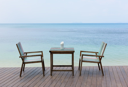 Wooden vintage table set with blue sky and sea backgroundの写真素材