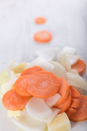 Sliced potato, onions and carrots on grunge white wood backgroundの写真素材