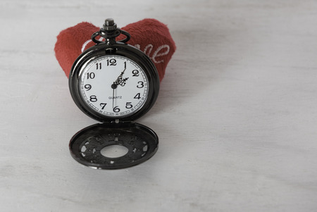 Classic pocket watch and red heart on grunge wood backgroundの写真素材