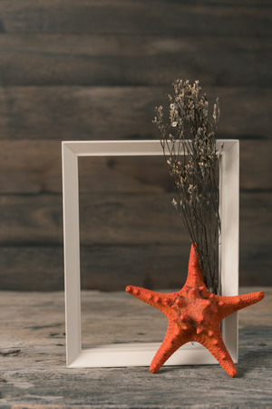 White wooden frame,starfish and dry flower on grunge wood backgroundの写真素材