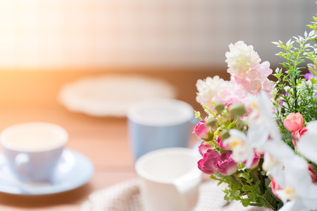 Blue and white coffee cups on wood table with flower bouquet decoration backgroundの写真素材