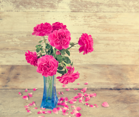 Still life with pink roses flower in blue vase on grunge wooden background,retro effectの写真素材
